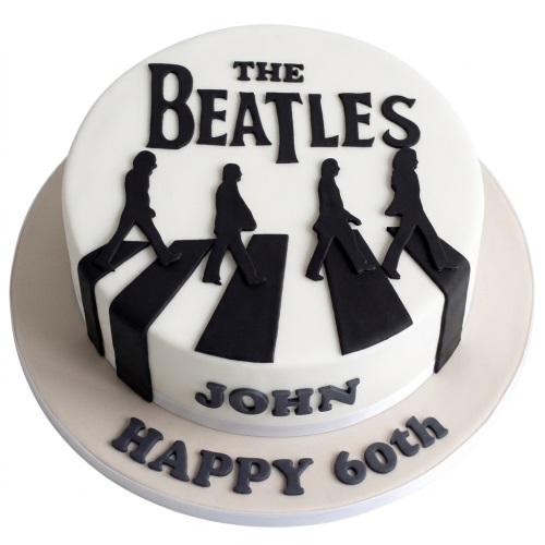 White round cake with black silhouettes of The Beatles crossing a zebra crossing and 'THE BEATLES' logo on top.