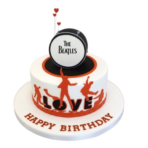 White round birthday cake with black and orange Beatles theme, drum topper, and red heart decorations.