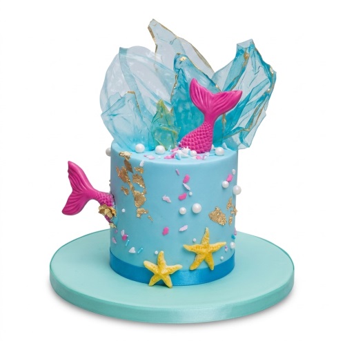 Light blue mermaid theme birthday cake with pink tails, gold foil, and sugar sails.