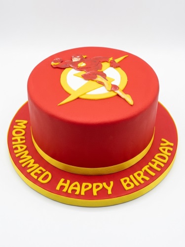 Red round cake with The Flash superhero and logo, yellow trim, personalised birthday message.