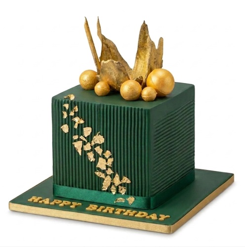 Square emerald green birthday cake with gold spheres and gold leaf flakes.
