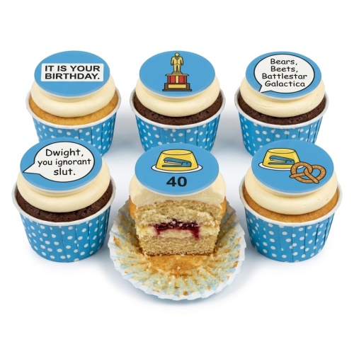 Six The Office themed cupcakes with blue and white polka dot wrappers. Toppers include quotes like 'IT IS YOUR BIRTHDAY.', 'Bears, Beets, Battlestar Galactica', 'Dwight, you ignorant slut.', a Dundie Award, a stapler in Jell-O with '40', and a stapler in Jell-O with a pretzel. One cupcake is cut open revealing a jam filling.