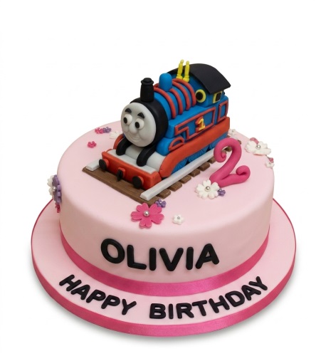 Pink round birthday cake with 3D Thomas the Tank Engine, train tracks, custom age topper, and sugar flowers.