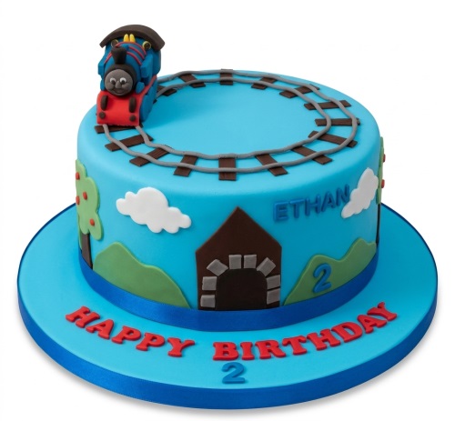 Blue round birthday cake with Thomas The Tank Engine figurine, railway tracks, hills, and custom age.