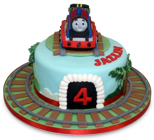Round blue Thomas The Tank Engine birthday cake with train tracks, tunnel, custom age, and name.
