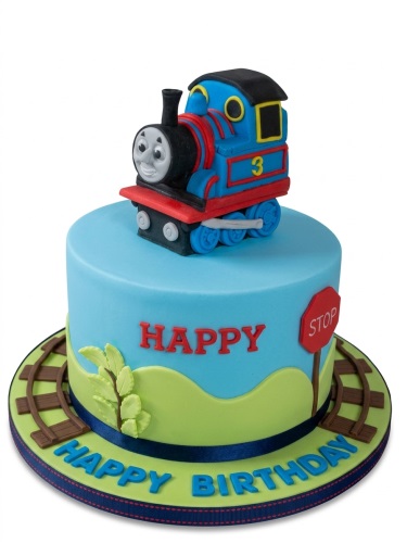 Thomas the Tank Engine themed birthday cake with a 3D train topper and edible tracks.