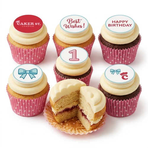 Baby celebration cupcakes with cream frosting, pink cases, blue bow, custom age '1' and 'Happy Birthday' toppers.