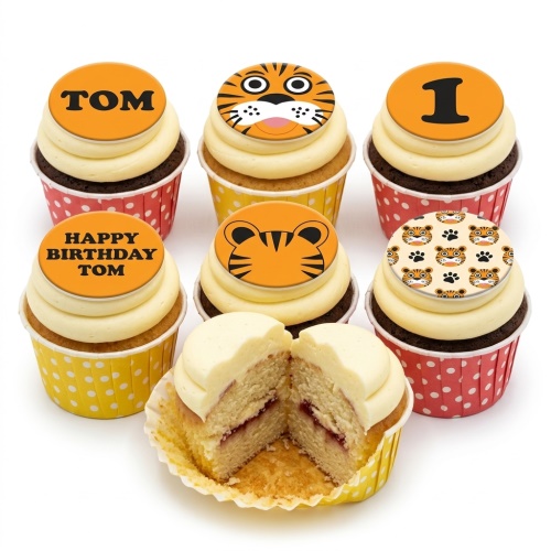 Six cupcakes with creamy frosting and orange tiger-themed edible toppers, including a cartoon tiger face, tiger head, paw print pattern, and a number 1.
