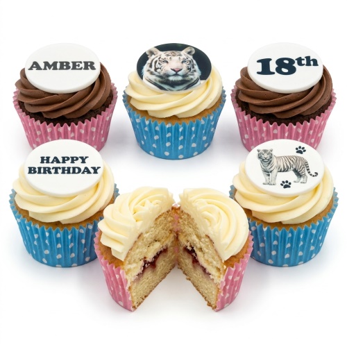 White tiger themed birthday cupcakes with custom age and name toppers, in pink and blue cases.