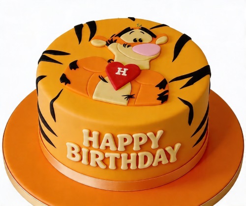 Round orange Tigger birthday cake with black stripes, a red heart, and 'Happy Birthday' message.