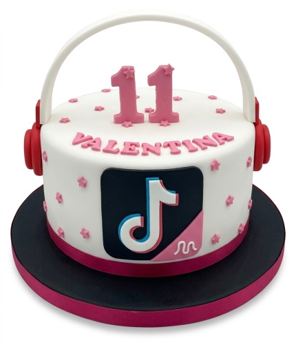 White round TikTok theme birthday cake with pink headphones, custom age topper, and personalised name.
