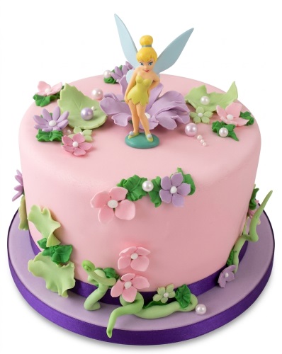 Round pink birthday cake with a Tinkerbell figurine, purple and pink sugar flowers, green leaves, and pearl decorations.