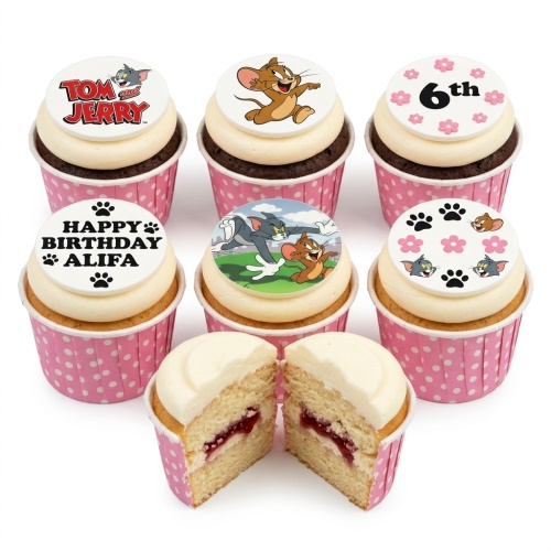 Tom and Jerry themed cupcakes with white icing, pink polka dot cases, and various edible toppers including characters, paw prints, and a custom age.
