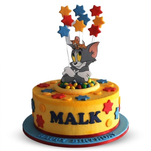 Round yellow Tom and Jerry birthday cake with star decorations and custom name.