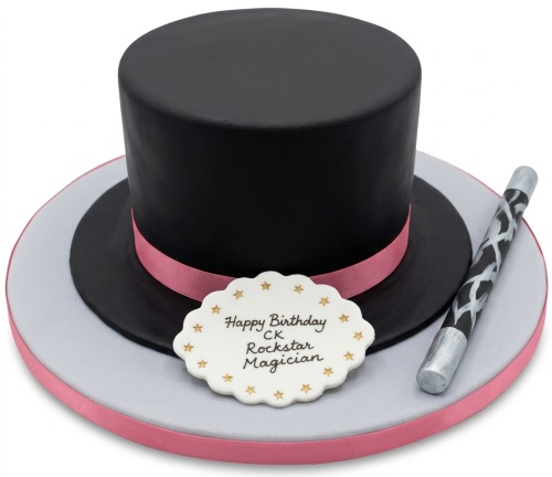 Black top hat cake with pink ribbon, silver and black magic wand, and a white plaque with a custom message.