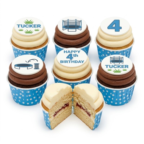 A set of six cupcakes with blue polka dot wrappers, some with white buttercream and some with chocolate frosting. Toppers feature blue trampolines, green grass with 'TUCKER', a large blue number '4', and 'HAPPY 4th BIRTHDAY'.
