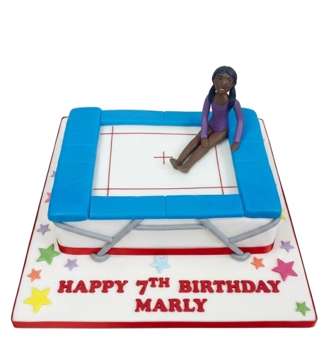 White birthday cake with blue trampoline, gymnast figure, and colourful stars for a custom age celebration.