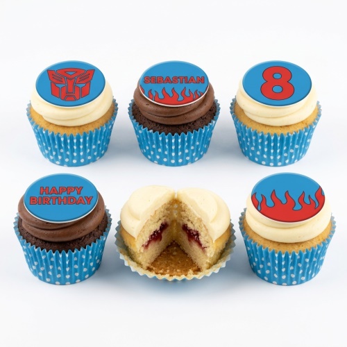 Set of six Transformers themed birthday cupcakes with blue and red toppers, some with flames, one with an Autobot logo, and one with a number 8.