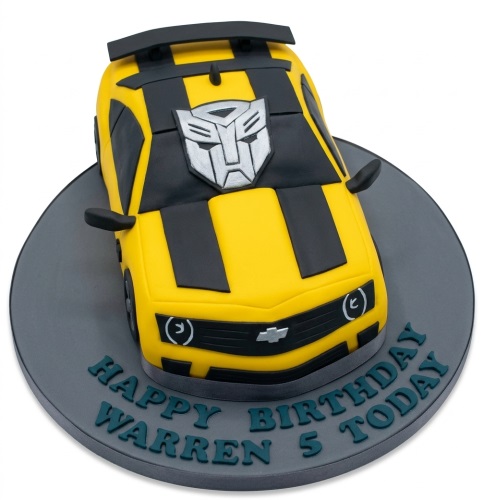 3D yellow and black Transformers car birthday cake with Autobot symbol and custom message board.