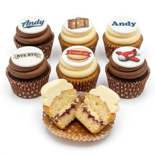 Assortment of travel theme cupcakes with personalised toppers including a suitcase and aeroplane.