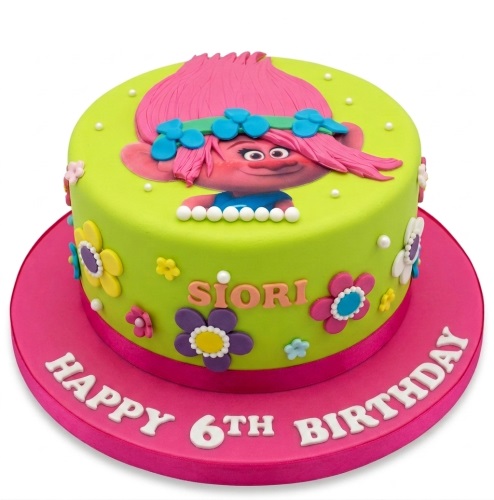 Round green Trolls Poppy character birthday cake with pink base, colourful flowers, custom name, and custom age message.
