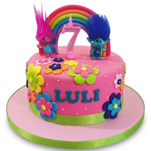 Pink Trolls birthday cake with Poppy and Branch figures, rainbow, colourful flowers, and custom age candle.