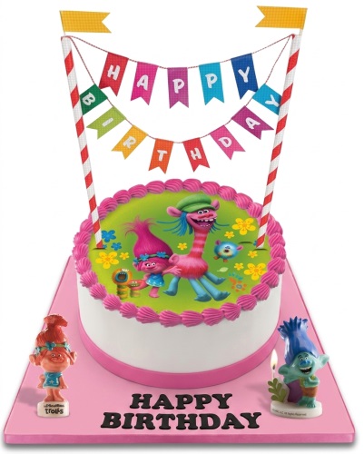 Round white Trolls theme birthday cake with green top, pink frosting border, Trolls edible image, 'Happy Birthday' banner, and Trolls figurines.
