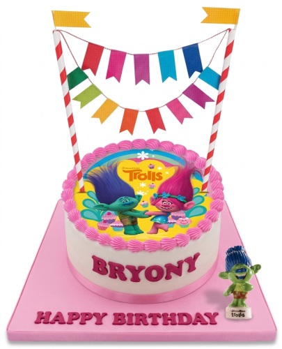 Round white Trolls birthday cake with pink frosting, featuring Poppy and Branch characters, bunting topper.