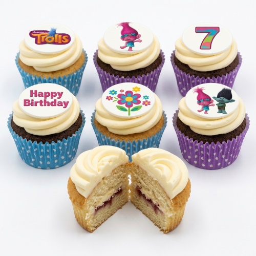 Cupcakes with white frosting and Trolls characters, a number 7, a floral design, and 'Happy Birthday' message toppers.