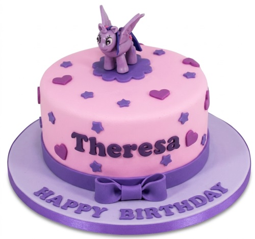 Pink round birthday cake with a purple unicorn figure, stars, hearts, and a purple bow.