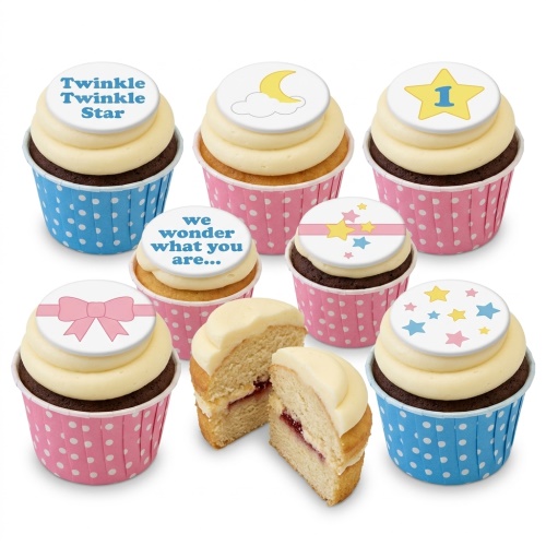 Assortment of gender reveal cupcakes with star, moon, bow, and text toppers in pink and blue wrappers.
