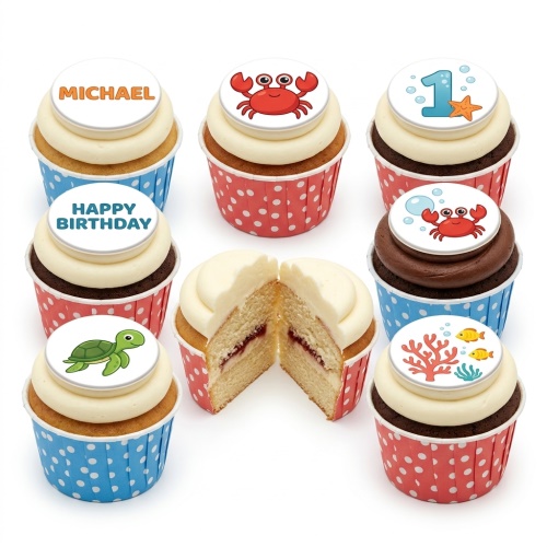 Under The Sea themed cupcakes with white and chocolate frosting, featuring edible toppers of crabs, turtles, coral, fish, and a number one.
