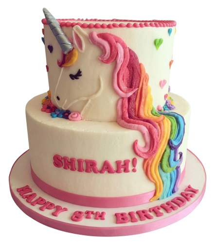Two-tier unicorn birthday cake with rainbow mane, silver horn, and colourful heart decorations.