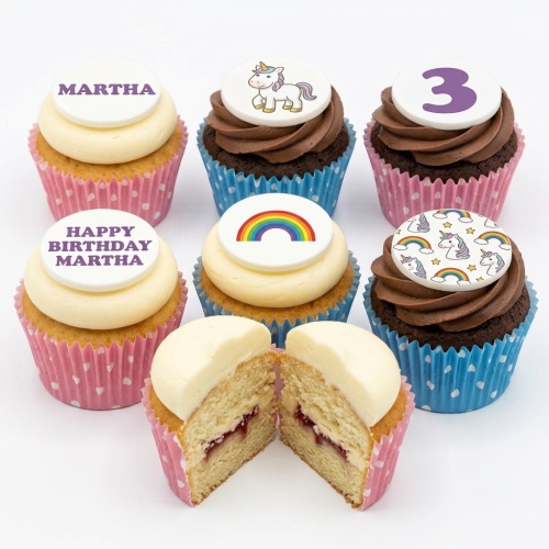 A selection of unicorn and rainbow themed birthday cupcakes with white and chocolate frosting, some with custom age and name toppers.