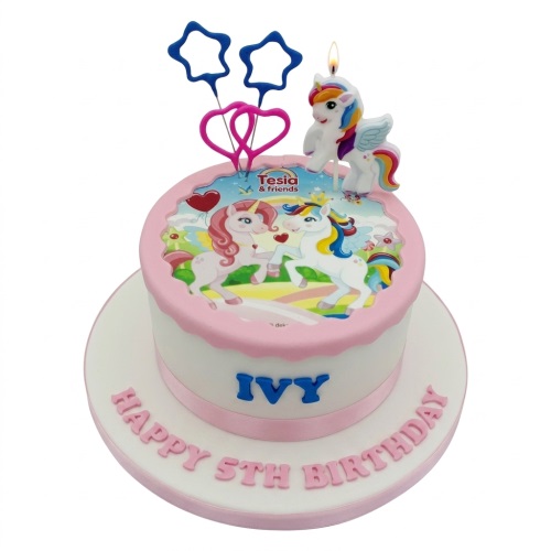 White and pink unicorn birthday cake with edible image, unicorn candle, star, and heart toppers.