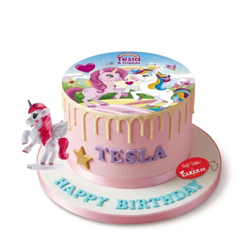 Pink round drip cake with unicorn edible image topper, 3D unicorn figurine, and gold star.