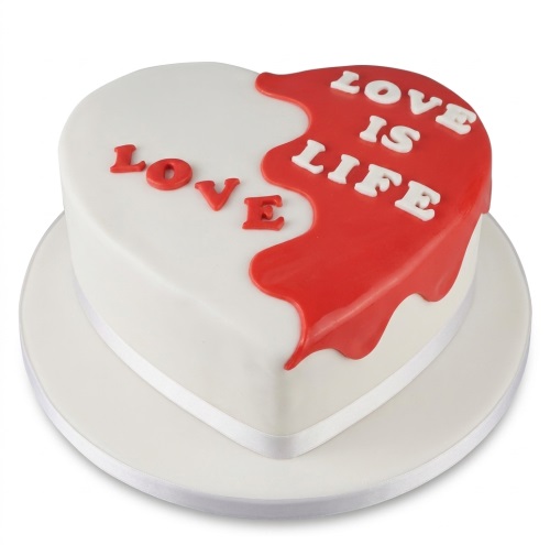 White heart-shaped cake with red "drip" effect and "LOVE IS LIFE" message in red and white.