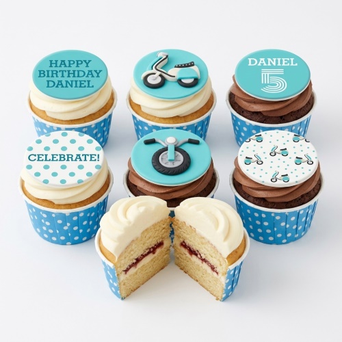 Set of blue and white scooter themed birthday cupcakes with custom age and name toppers.