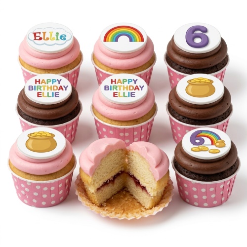Assortment of cupcakes with pink and chocolate frosting, topped with edible rainbow, pot of gold, and custom age/name designs in pink polka dot cases.