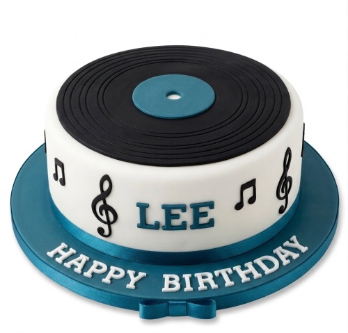 Round white birthday cake with a black vinyl record top, blue centre, and musical notes. Features a blue ribbon and custom name.