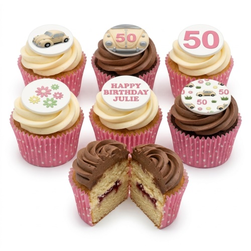 Assortment of vanilla and chocolate cupcakes with vintage car, floral, and custom age toppers in pink cases.