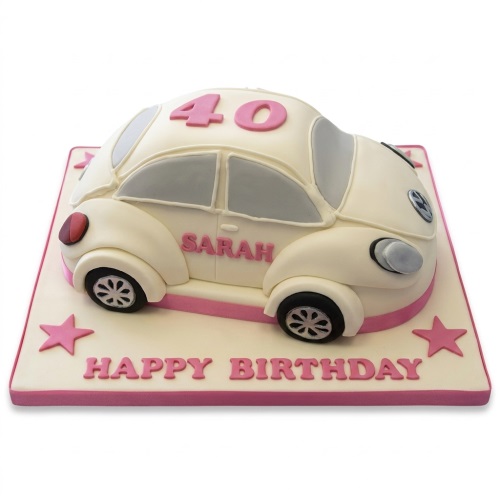 Cream Volkswagen Beetle shaped birthday cake with pink accents, custom age, and a personalised name.
