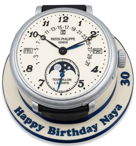 3D Patek Philippe watch birthday cake with cream dial, silver casing, black strap, and custom age and message on the board.