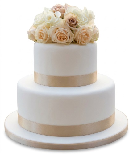 Elegant two-tier wedding cake with white fondant, champagne ribbon, and cream and blush rose bouquet.