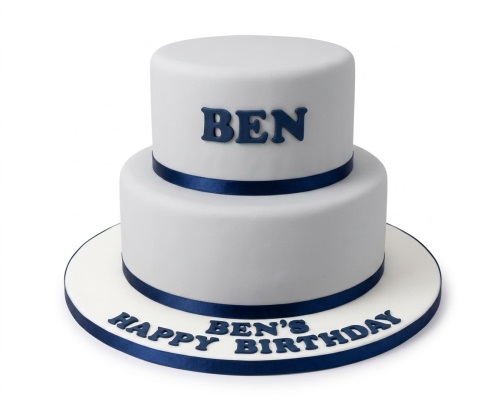 Two-tier white birthday cake with navy blue ribbon and custom name.