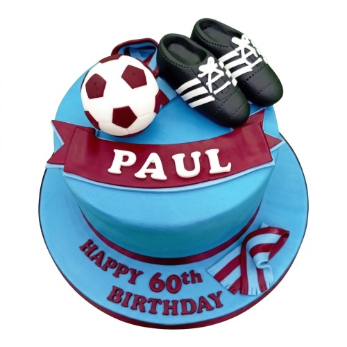 Round football theme birthday cake with edible ball, boots, scarf, and custom age banner.