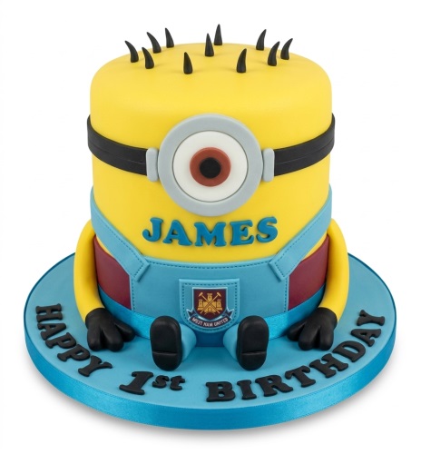 Yellow Minion character birthday cake with blue overalls, a single eye, and black hair spikes, with "Happy 1st Birthday" on the board.