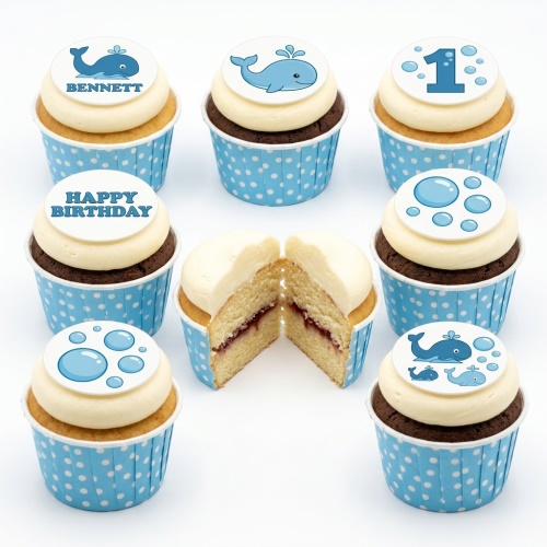 Blue whale and bubble themed cupcakes in polka dot cases with custom age and name toppers.