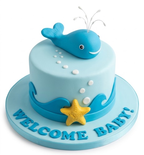 Single-tier light blue cake with a blue whale topper, white bubbles, blue waves, a yellow starfish, and a personalised message.