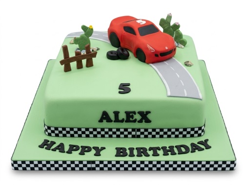 Two-tier square green cake with a red sports car, road, cacti, fence, and a custom age topper.